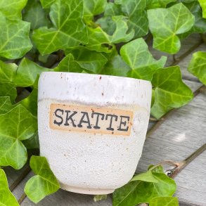 Kop med teksten SKATTE