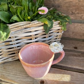 Fineste lyser�de kop med blomst p� hanken