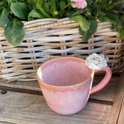 Fineste lyser�de kop med blomst p� hanken